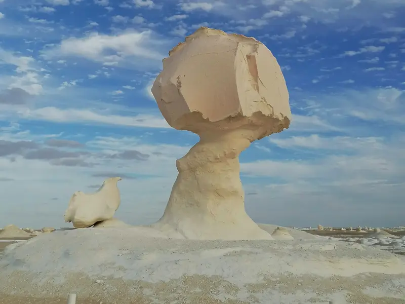 Vom Wind geformte Pilz- und Huhn-Felsformationen aus Kalkstein in der surrealen Landschaft der Weißen Wüste Ägyptens.