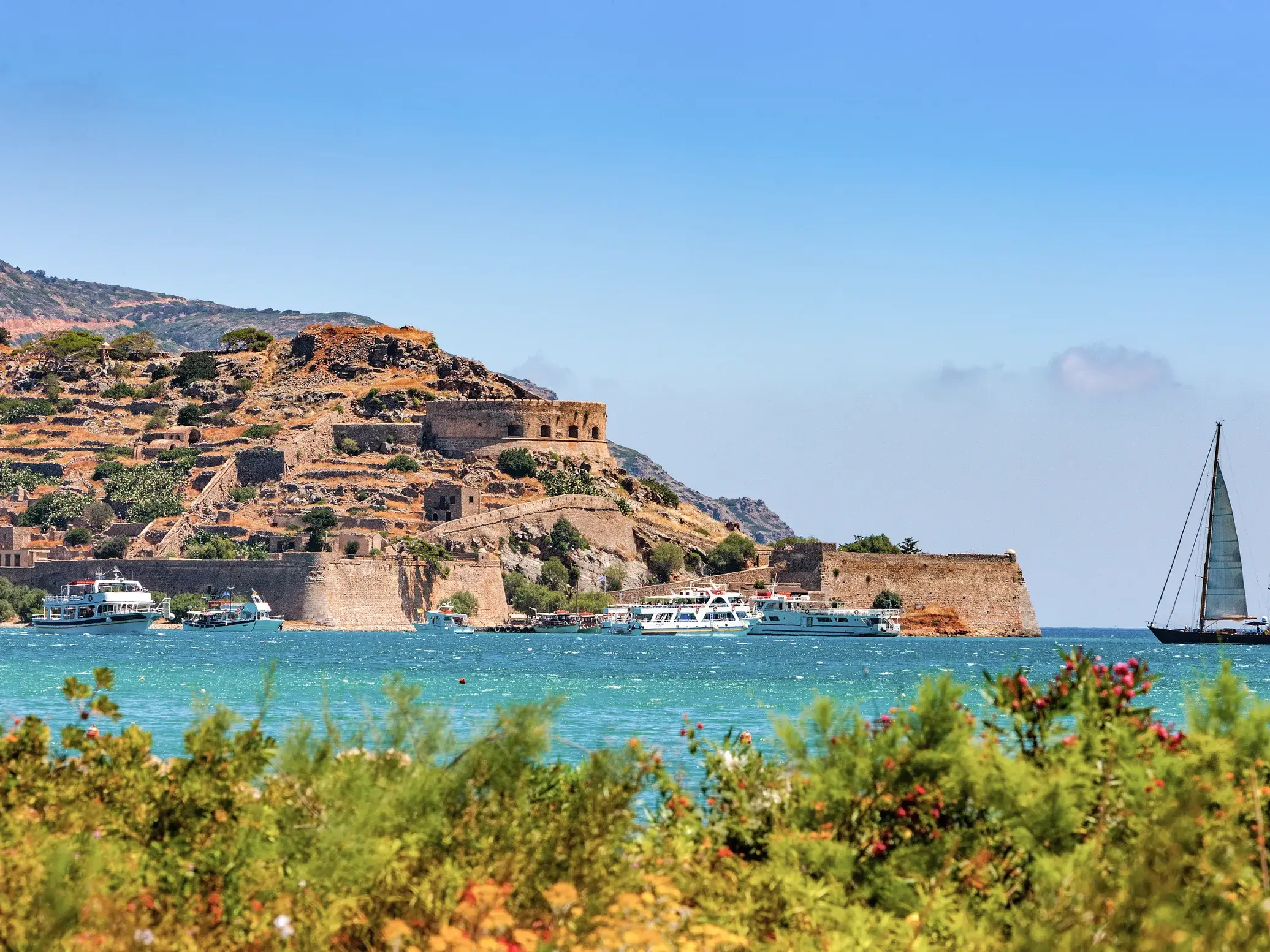 Sonniger Blick über das Meer zur Festung Spinalonga auf Kreta, wohin ein Bootsausflug während der Studienreise führt.