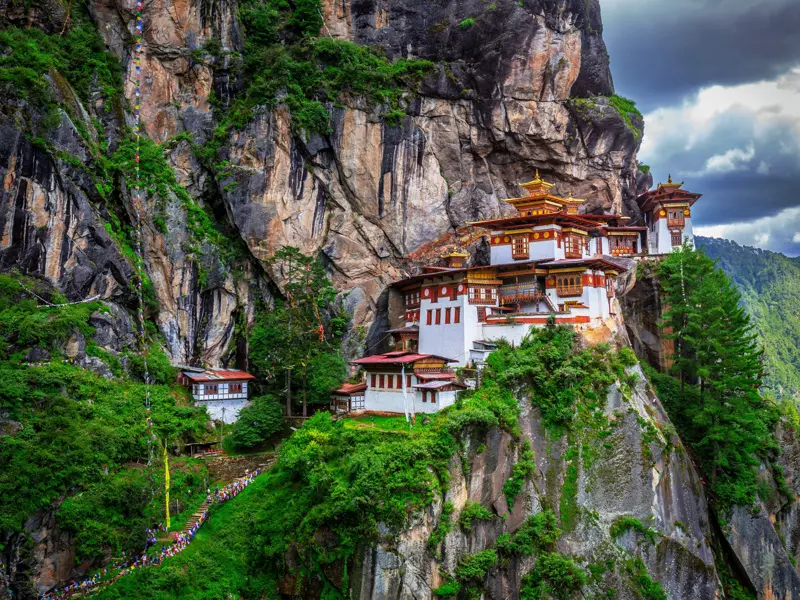 Das berühmte Kloster Taktshang, das Tigernest, klebt an einer steilen Felswand hoch über dem grünen Paro-Tal in Bhutan.
