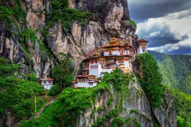 Das berühmte Kloster Taktshang, das Tigernest, klebt an einer steilen Felswand hoch über dem grünen Paro-Tal in Bhutan.