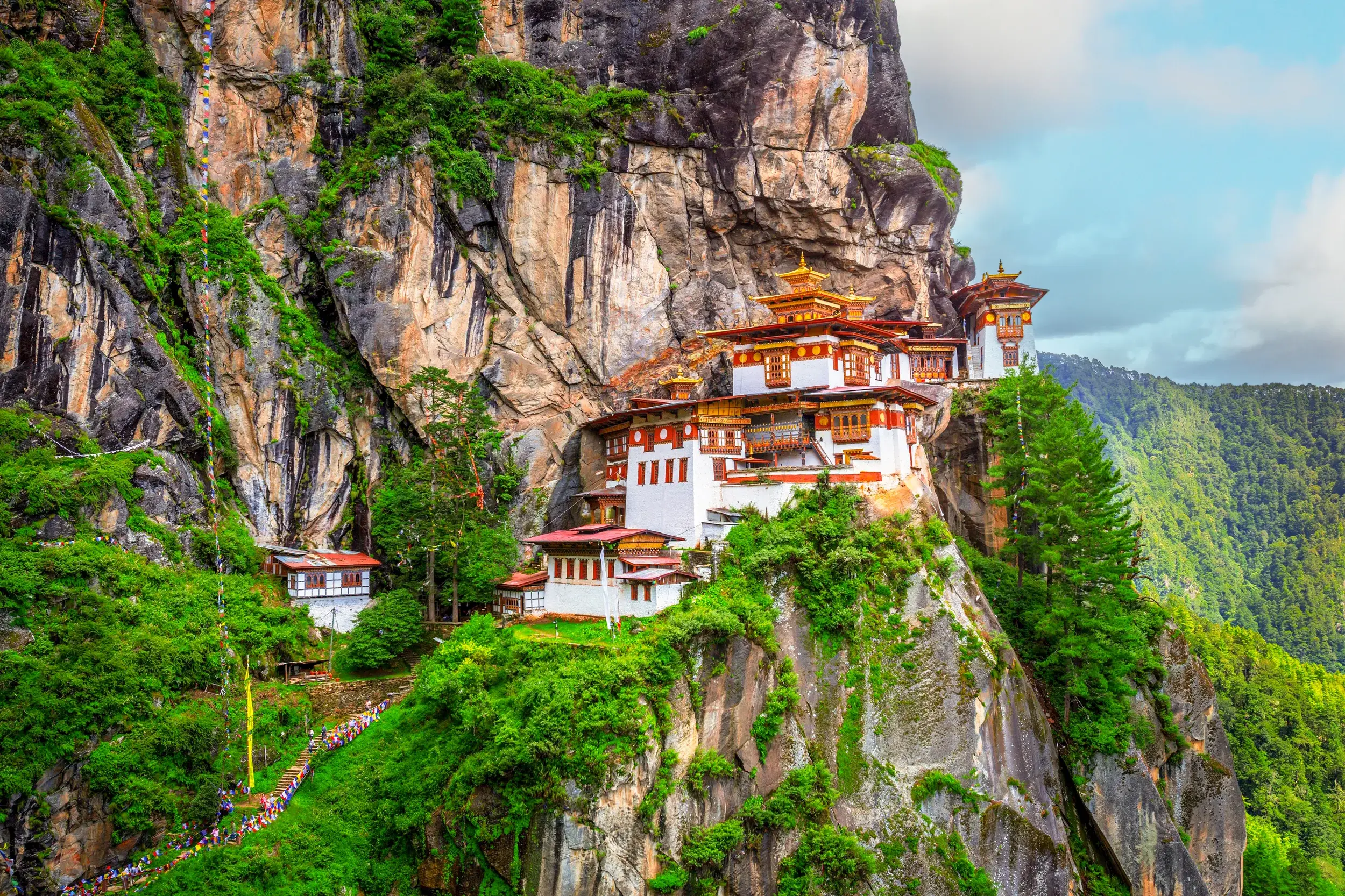 Blick auf das berühmte Tigernest-Kloster Taktshang, das während einer Wanderung in Bhutan an einer steilen Felswand hoch über dem grünen Paro-Tal thront.