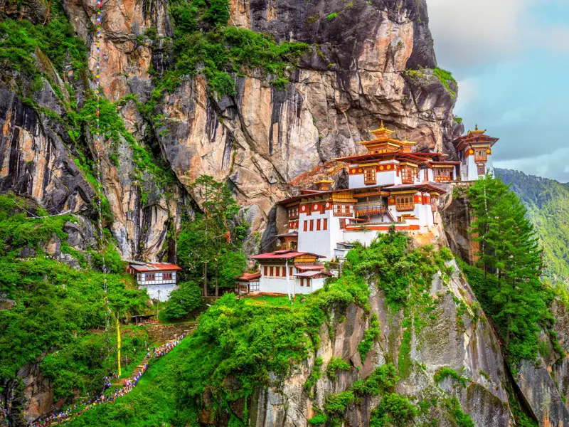 Blick auf das berühmte Tigernest-Kloster Taktshang, das während einer Wanderung in Bhutan an einer steilen Felswand hoch über dem grünen Paro-Tal thront.