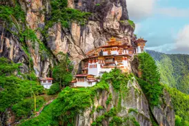 Blick auf das berühmte Tigernest-Kloster Taktshang, das während einer Wanderung in Bhutan an einer steilen Felswand hoch über dem grünen Paro-Tal thront.