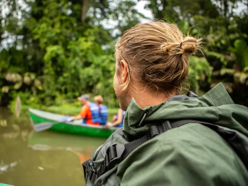 Teilnehmer einer Kleingruppenreise bei einer Bootstour durch die grünen Kanäle des Tortuguero Nationalparks in Costa Rica.