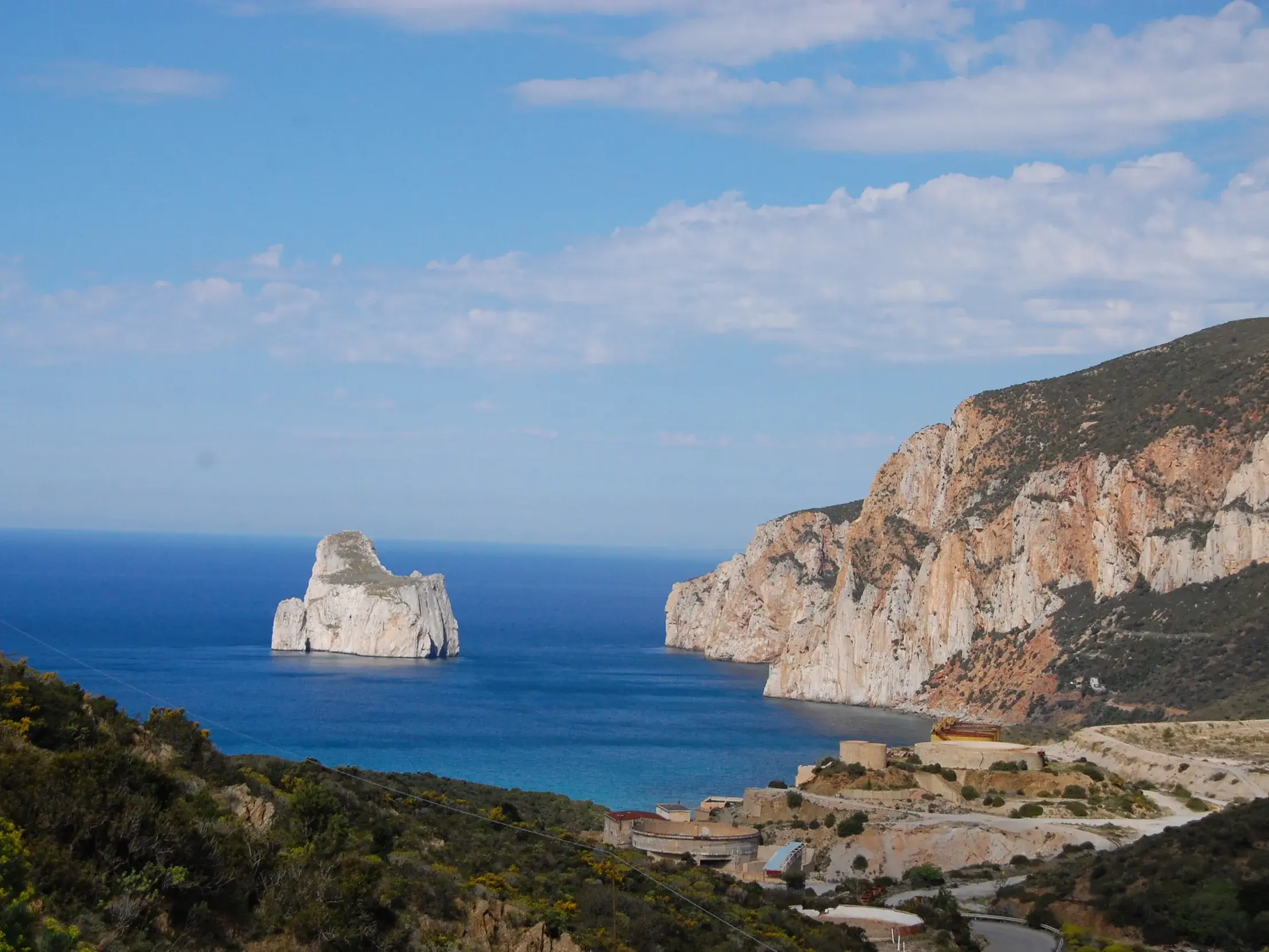 Wanderung an Sardiniens wilder Küste mit Aussicht auf den Kalkfelsen Pan di Zucchero und alte Minenanlagen.