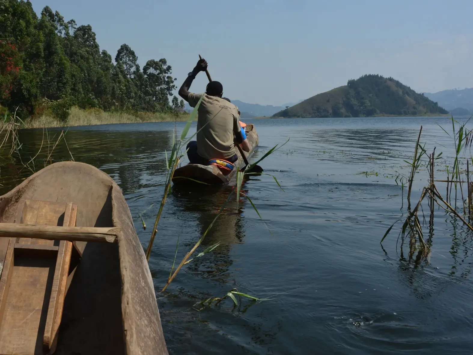 Mit einem traditionellen Holzboot auf dem Kivu-See, vorbei an der grünen Fjord-Landschaft des Kongo-Nile-Trails.