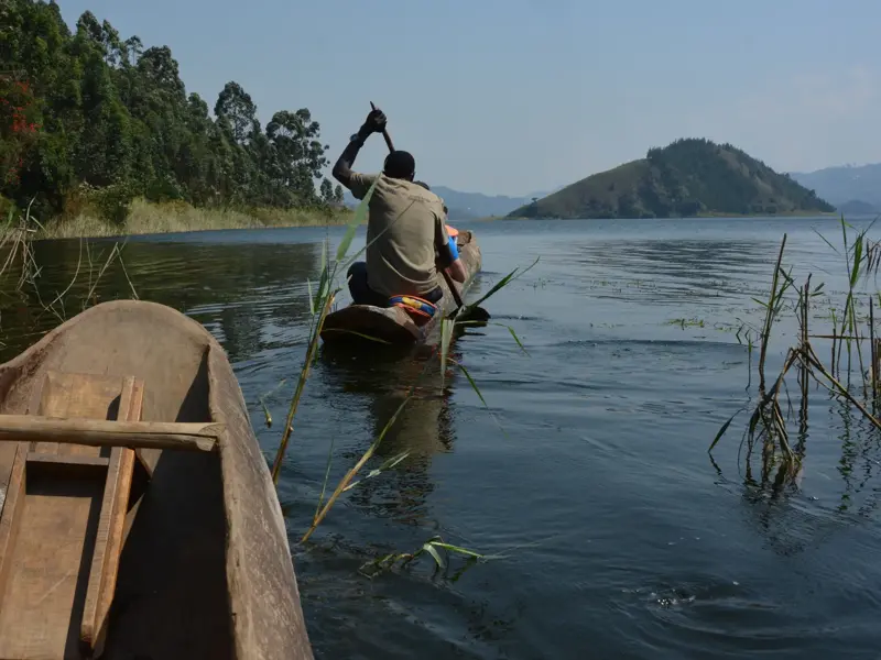 Mit einem traditionellen Holzboot auf dem Kivu-See, vorbei an der grünen Fjord-Landschaft des Kongo-Nile-Trails.