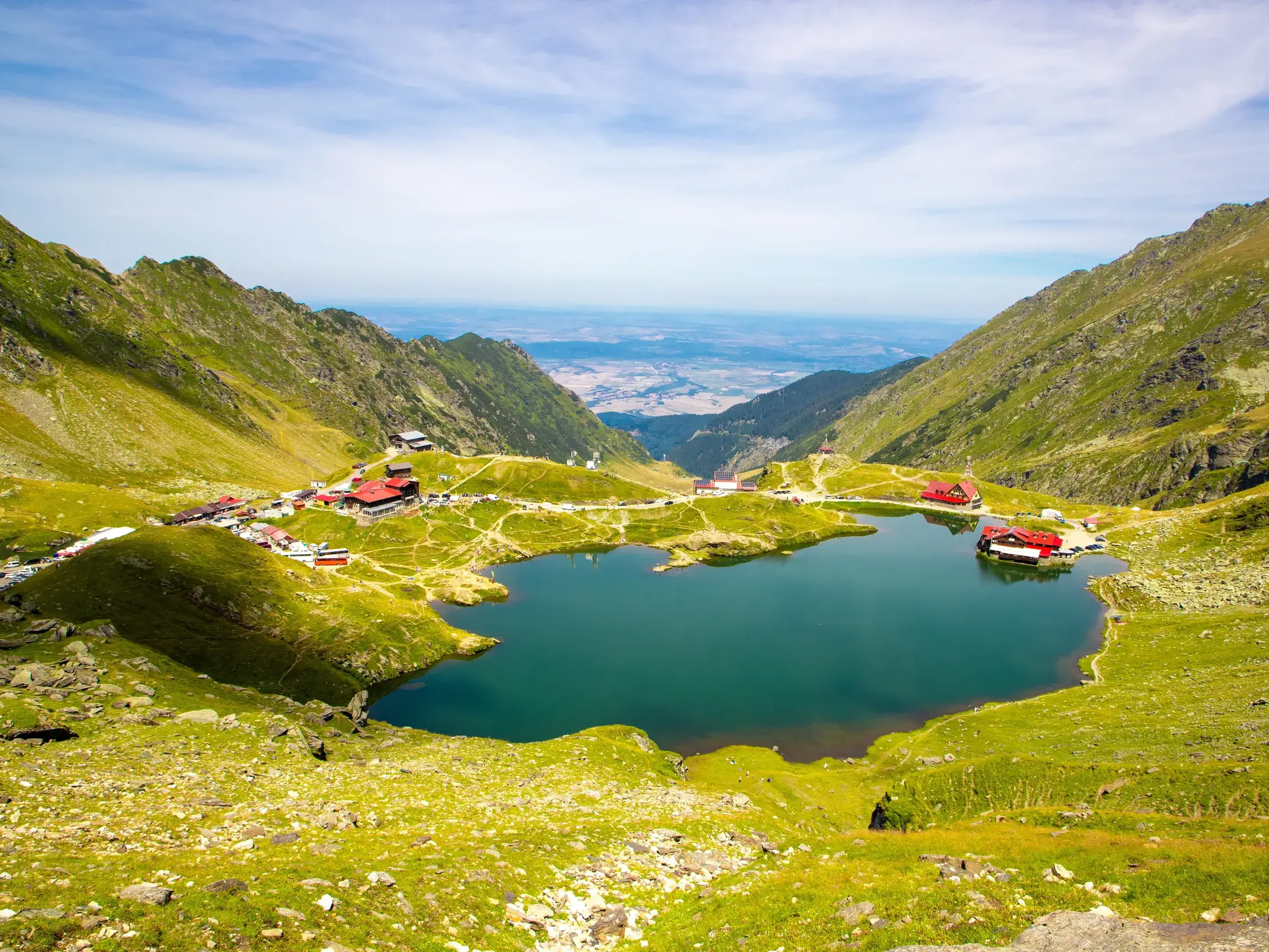 Aussicht von den Wanderwegen des Fagaras Gebirges auf den malerischen Balea-See und die umliegenden Berghütten.