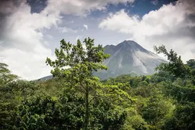 Panoramablick auf den Vulkan Arenal in Costa Rica durch den üppigen mittelamerikanischen Dschungel während einer Studienreise.