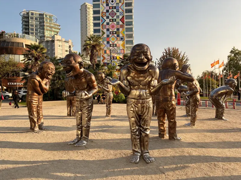 Die bekannten Bronzefiguren der A-maze-ing Laughter Installation lachen ausgelassen im Morton Park in Vancouver.