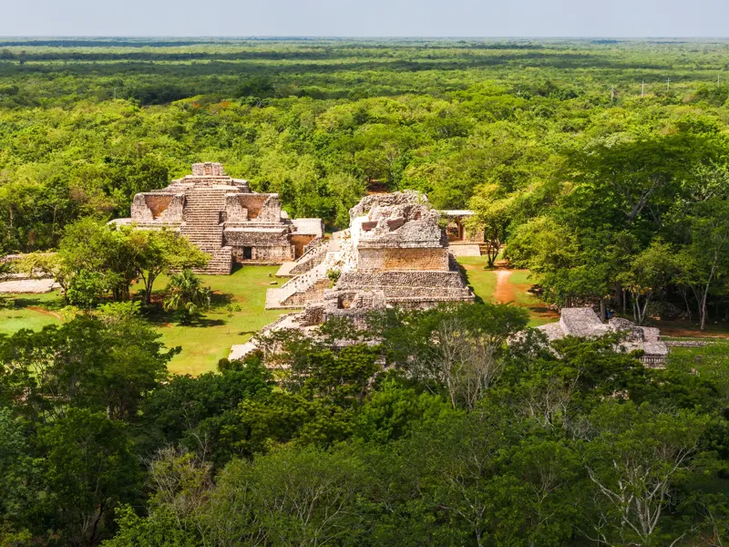 Luftaufnahme der Maya-Ruinen von Ek Balam, deren alte Steinpyramiden aus dem dichten grünen Dschungel Yucatans ragen.
