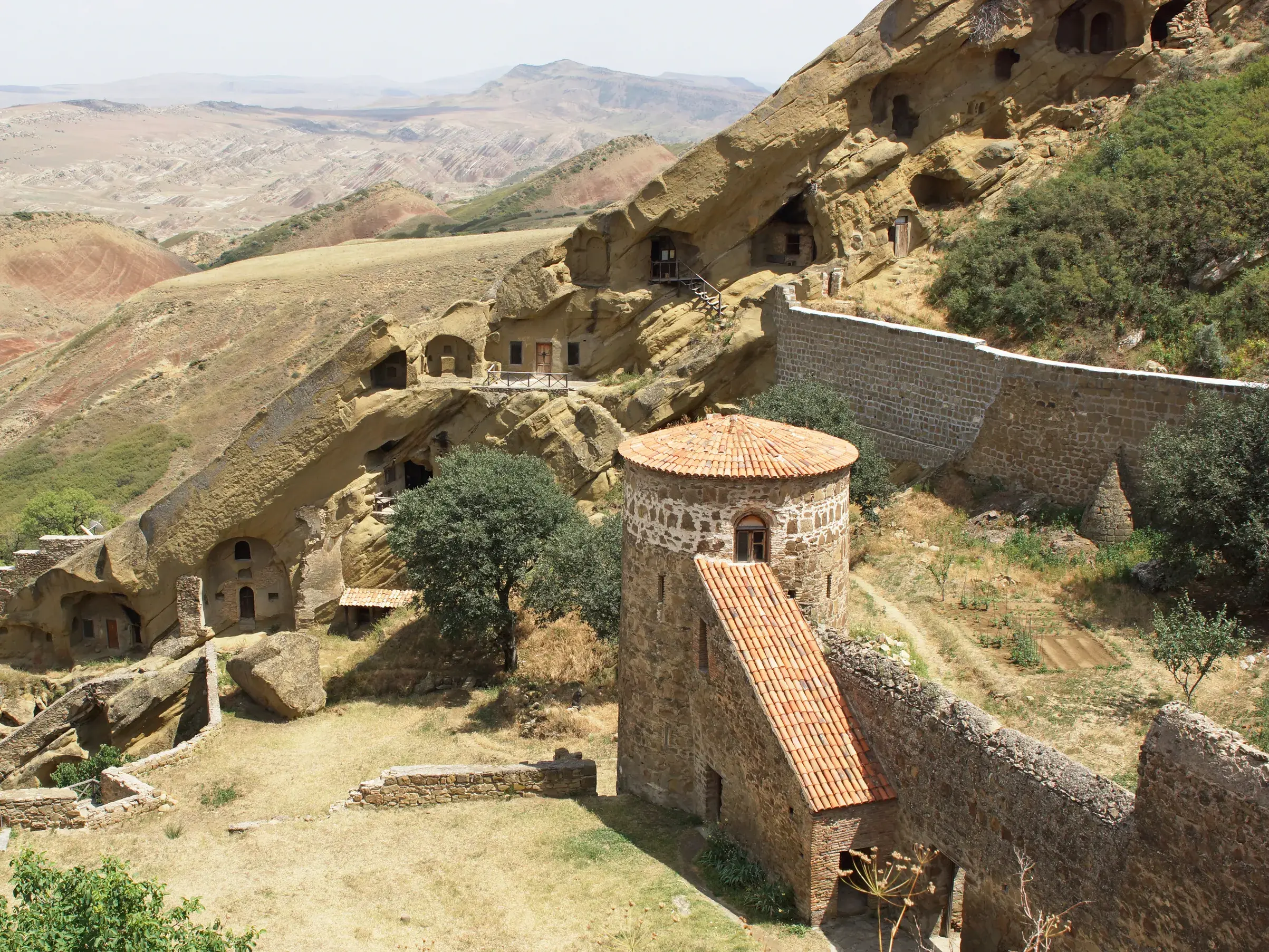 Das historische Felsenkloster David Gareja mit Wehrturm und Höhlenbauten in der kargen Steppenlandschaft Ostgeorgiens.