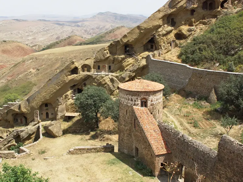Das historische Felsenkloster David Gareja mit Wehrturm und Höhlenbauten in der kargen Steppenlandschaft Ostgeorgiens.