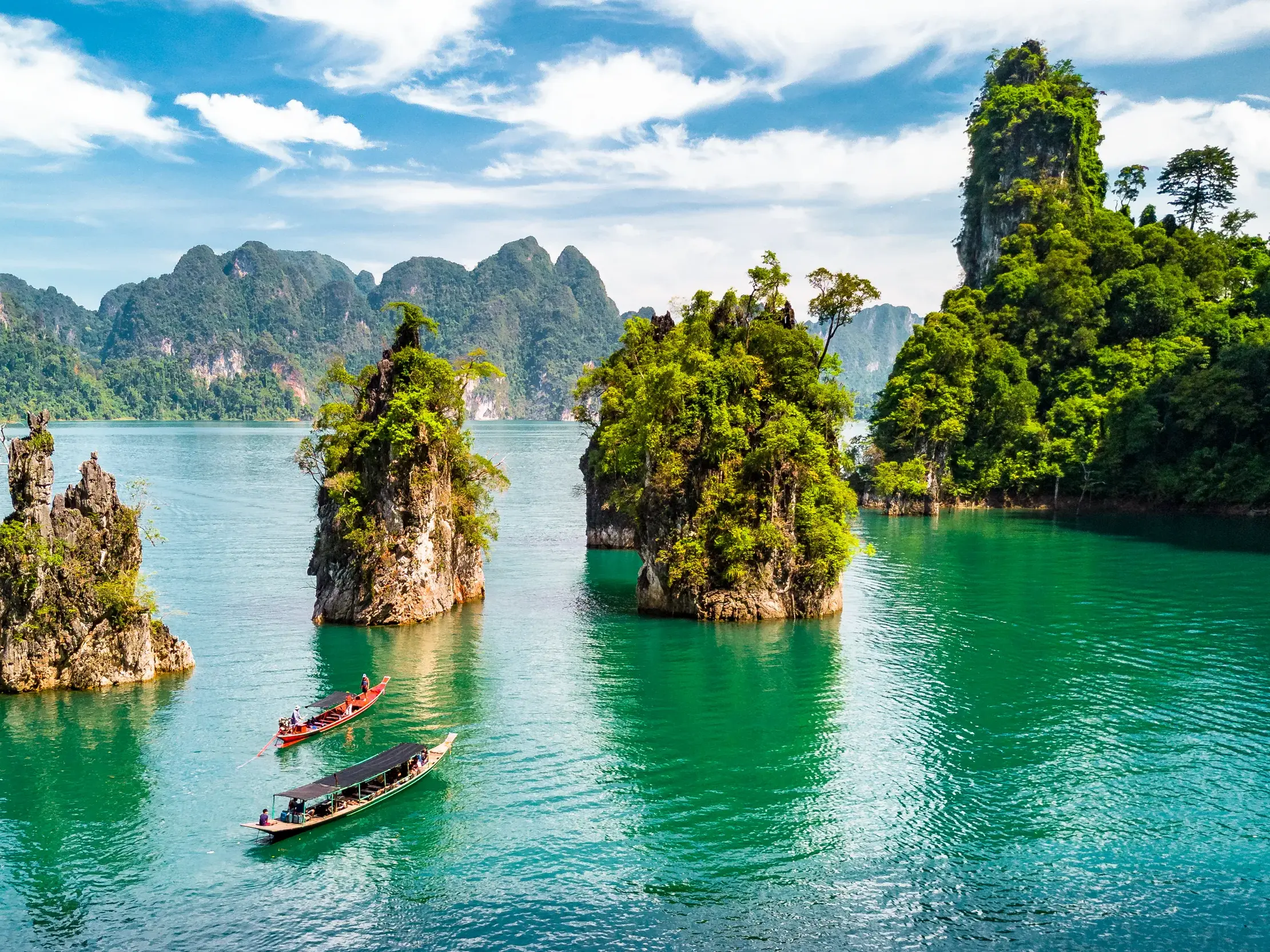 Eine Kleingruppenreise per Langschwanzboot auf dem Chiao-Lan-See, vorbei an imposanten, grünen Karstfelsen in Khao Sok.