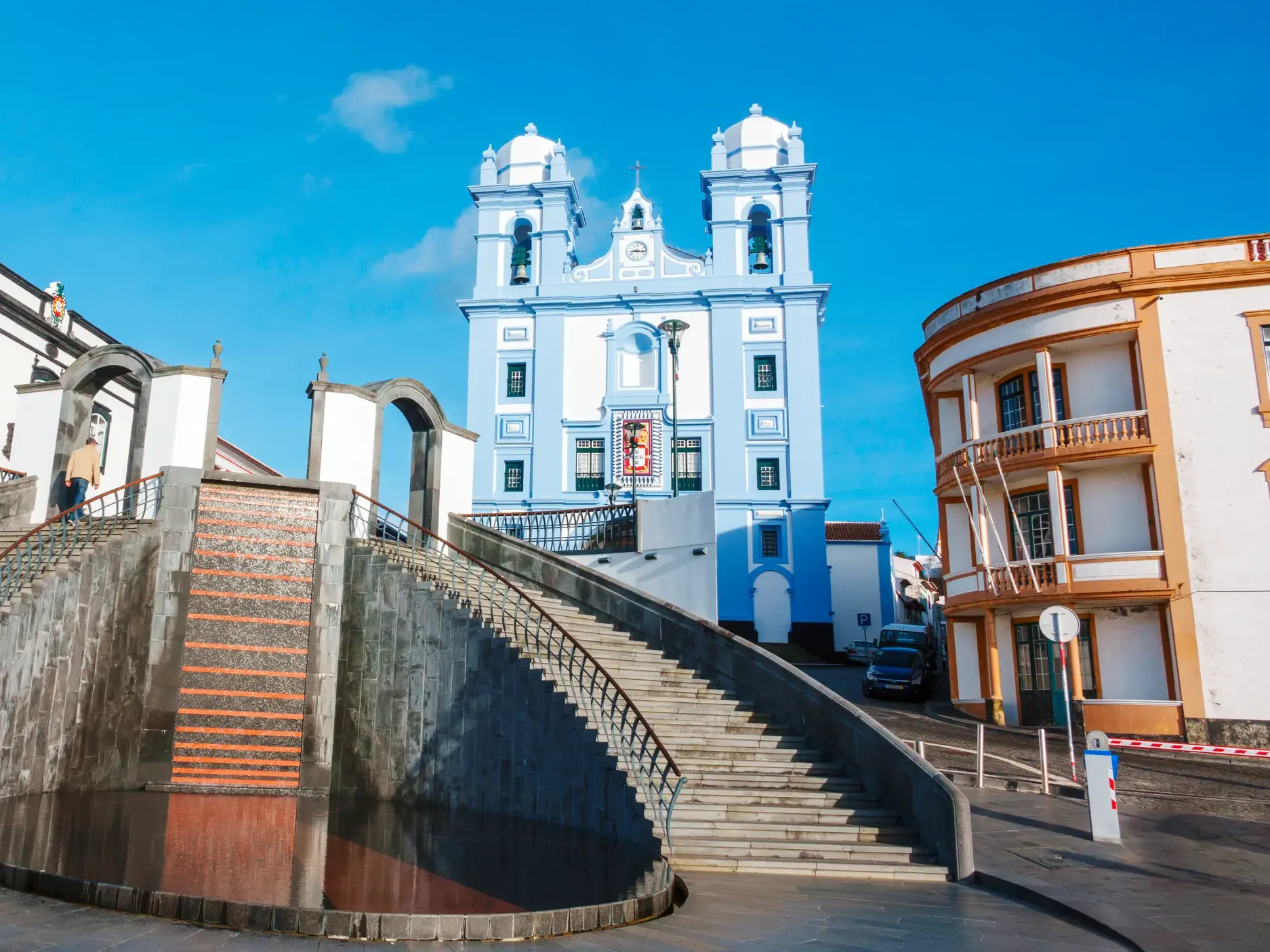 Sonnige Ansicht einer blauen Kirche mit großer Treppe in der UNESCO-Welterbestadt Angra do Heroísmo auf Terceira.