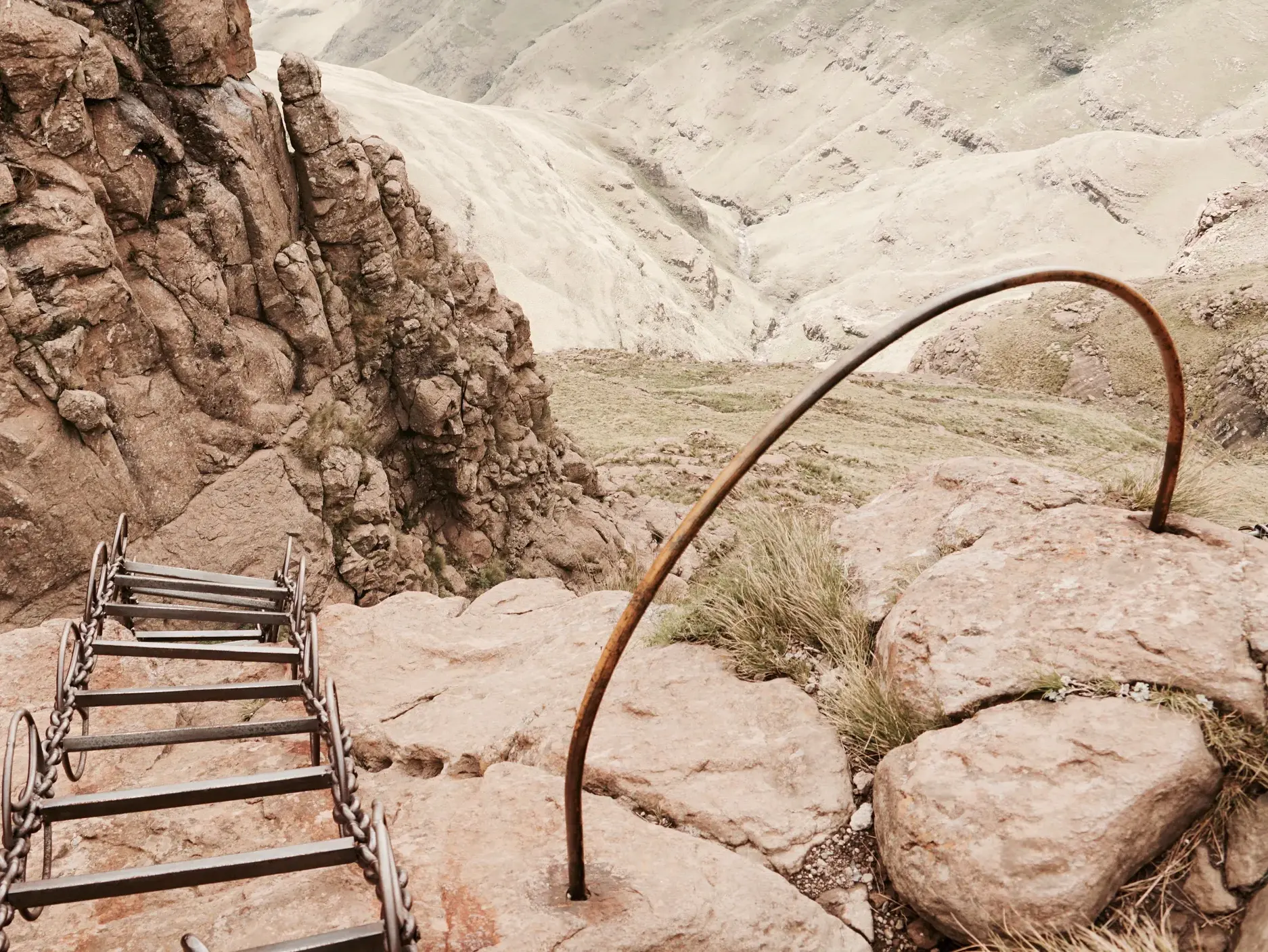 Die eiserne Chain Ladder führt steil eine Felswand in der Berglandschaft der Drakensberge in Südafrika hinauf.