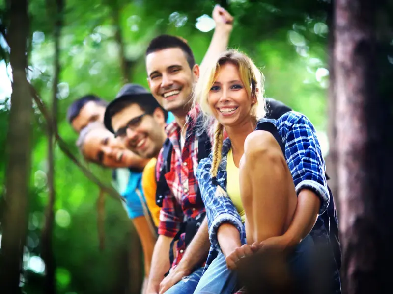 Junge Teilnehmer einer Gruppenreise für junge Leute lachen und posieren für ein Foto in der üppigen, grünen Natur Costa Ricas.