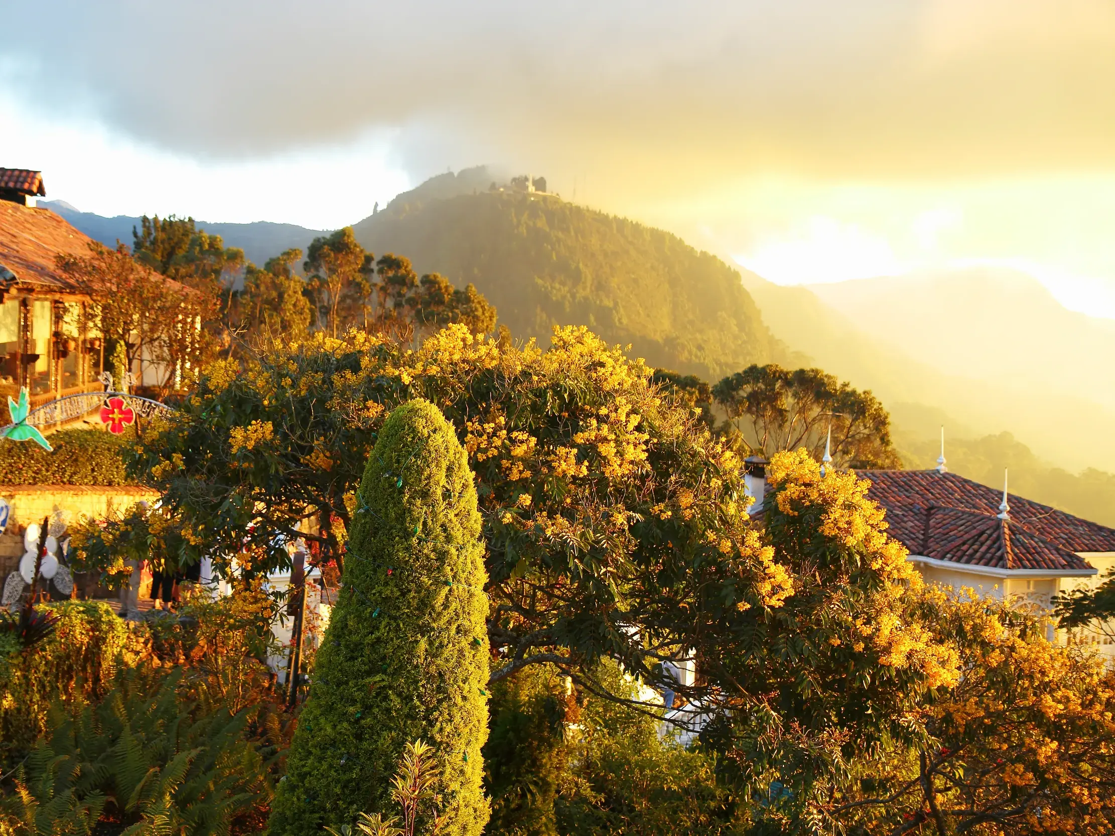 Goldenes Abendlicht über den Dächern von Bogotá mit spektakulärem Blick auf den berühmten Berg Monserrate in Kolumbien.