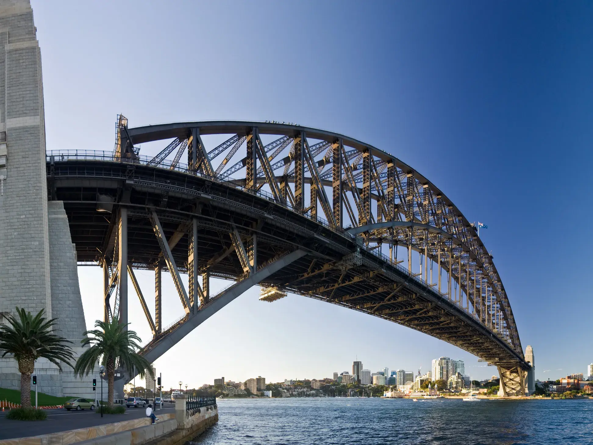 Die Stahlbogenkonstruktion der Sydney Harbour Bridge spannt sich bei strahlend blauem Himmel über den Hafen zur Skyline Sydneys.