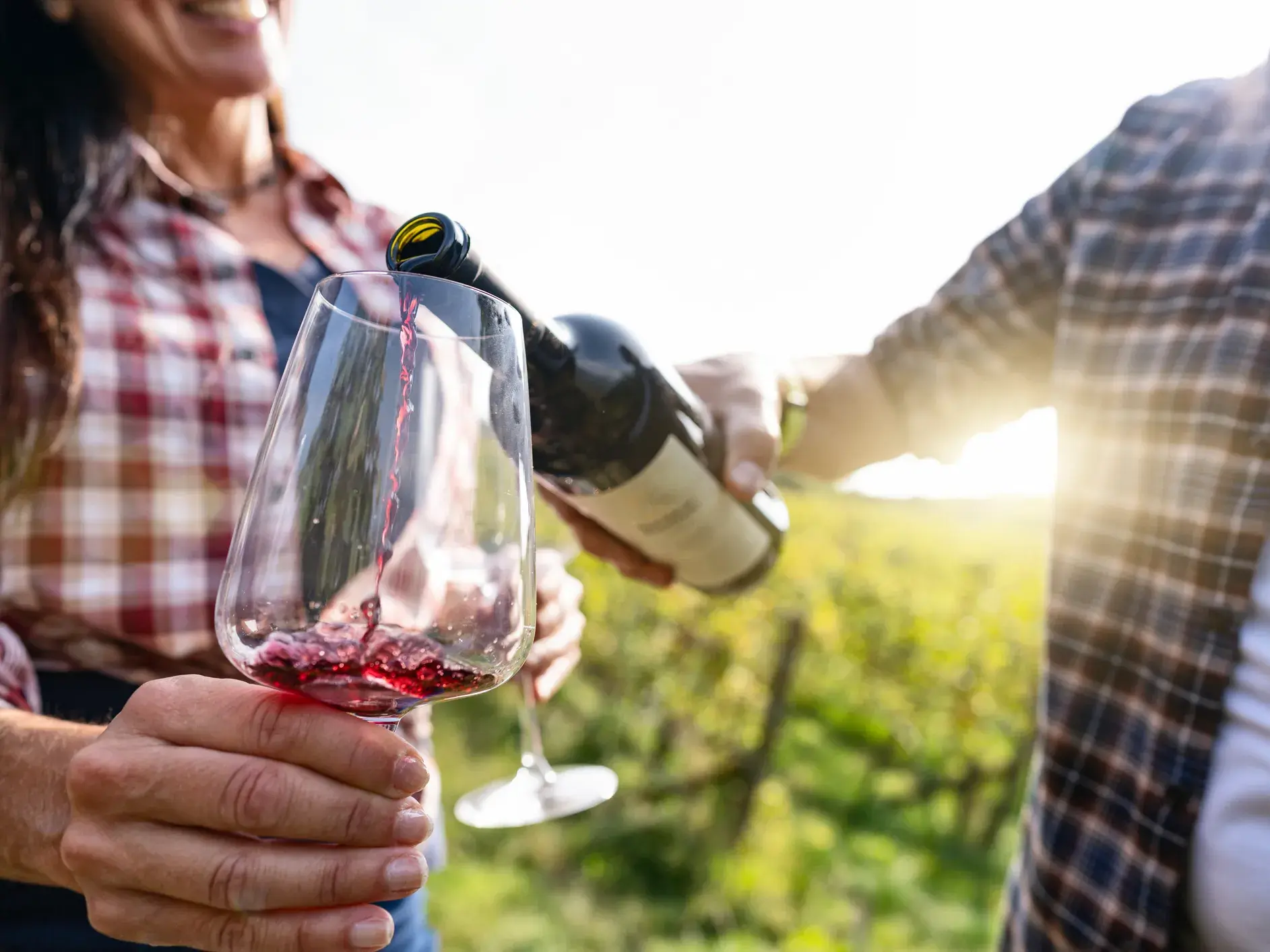 Nahaufnahme einer Weinprobe in Aragonien: Eine Person schenkt temperamentvollen Garnacha-Rotwein in ein Weinglas ein.