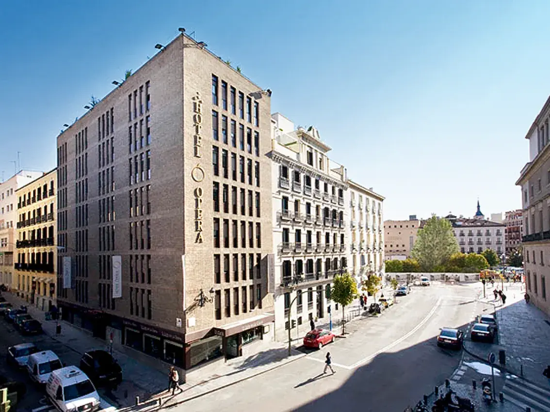 Sonnige Außenansicht des zentral gelegenen Hotel Opera an einer belebten Straßenecke in der Altstadt von Madrid.
