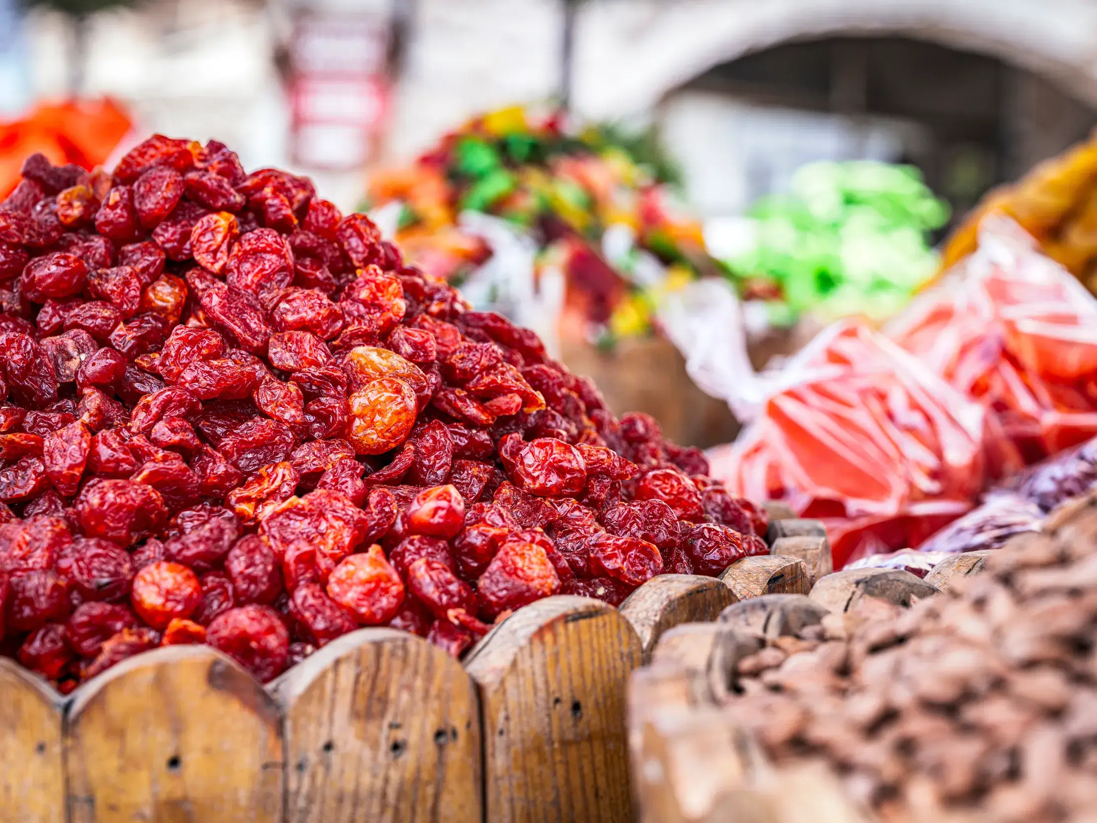 Bunter Marktstand auf dem Wochenmarkt in Gülsehir, Kappadokien, mit aufgetürmten roten Trockenfrüchten in Holzkisten.