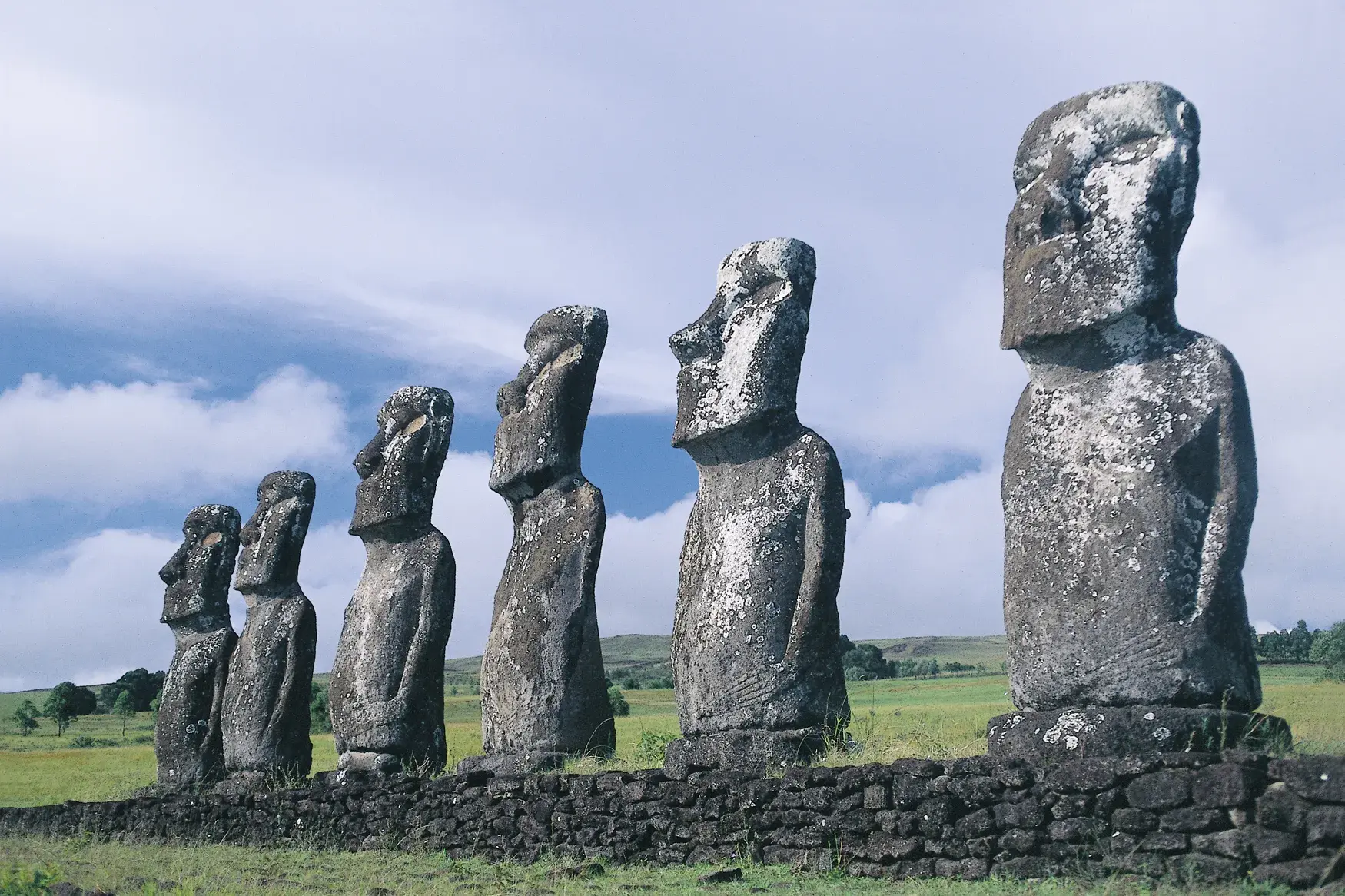Die eindrucksvollen Moai-Statuen von Ahu Tongariki stehen aufgereiht und blicken über die grüne Vulkanlandschaft der Osterinsel.