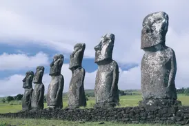 Die eindrucksvollen Moai-Statuen von Ahu Tongariki stehen aufgereiht und blicken über die grüne Vulkanlandschaft der Osterinsel.