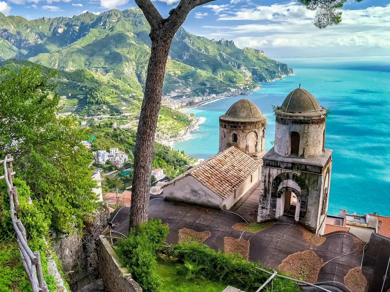 Malerischer Blick von Ravello über die Steilklippen der Amalfitana mit historischen Kirchtürmen und türkisblauem Meer.