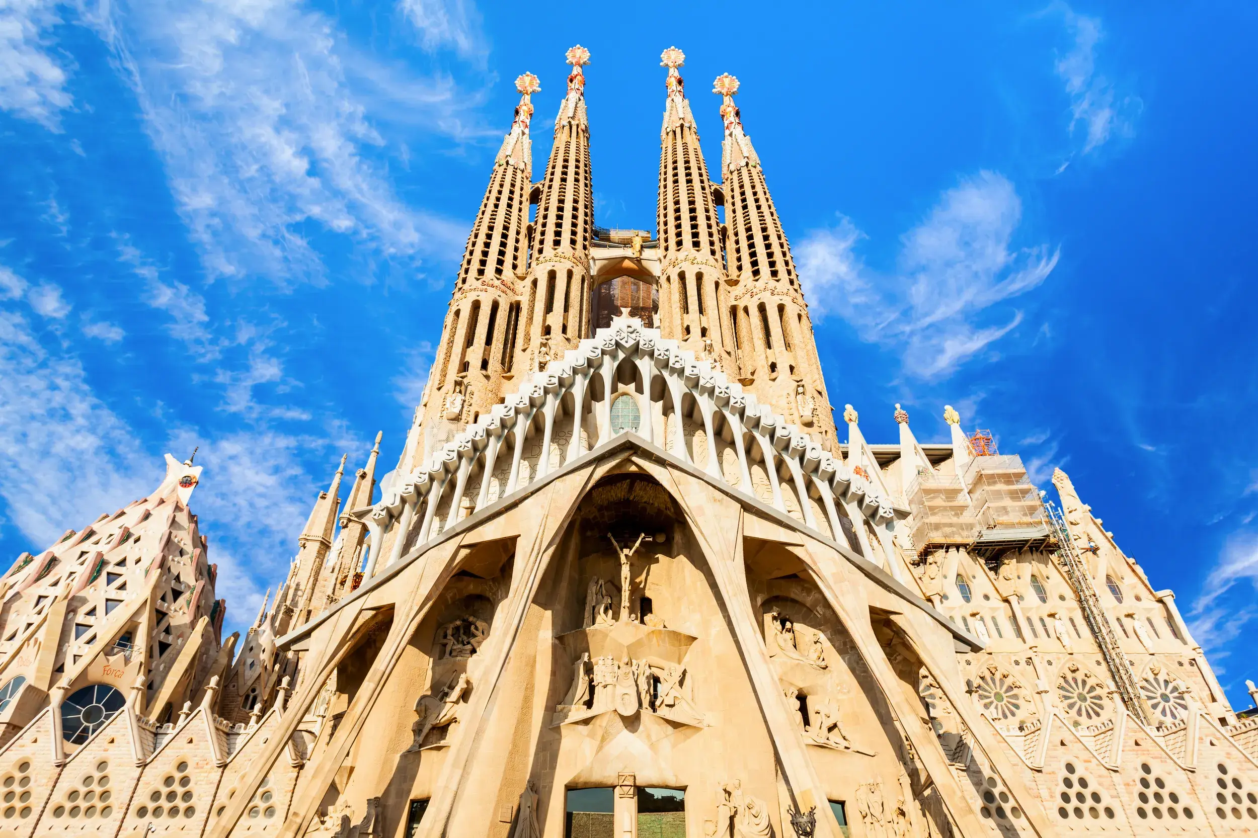 Die beeindruckende Fassade und die markanten Türme von Antoni Gaudís La Sagrada Família in Barcelona bei Sonnenschein.