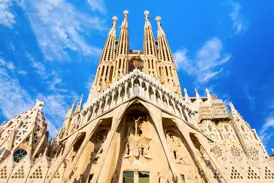 Die beeindruckende Fassade und die markanten Türme von Antoni Gaudís La Sagrada Família in Barcelona bei Sonnenschein.