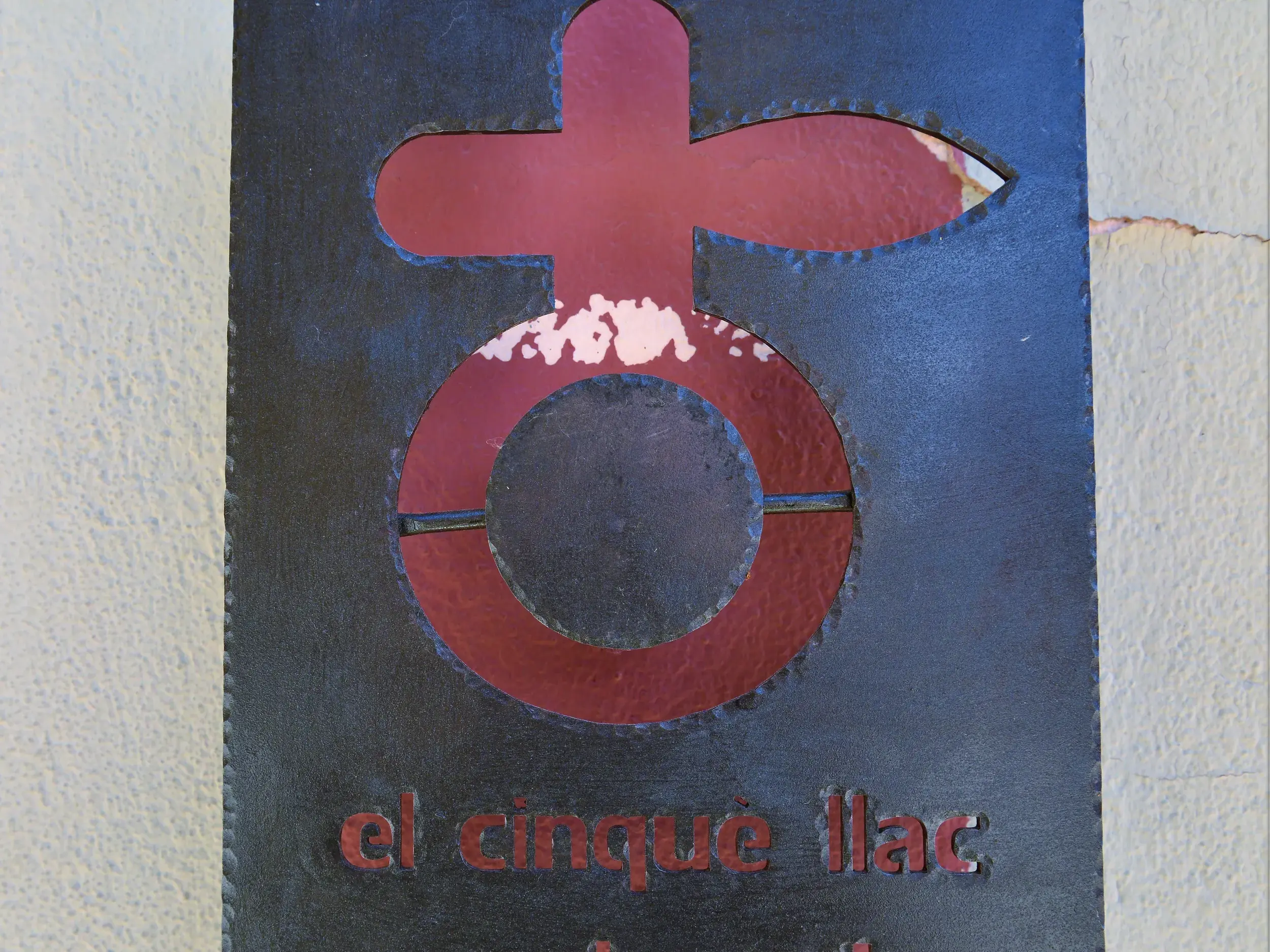 Nahaufnahme des Schilds El Cinqué Llac, das Symbol der Trekkingroute in den spanischen Pyrenäen.