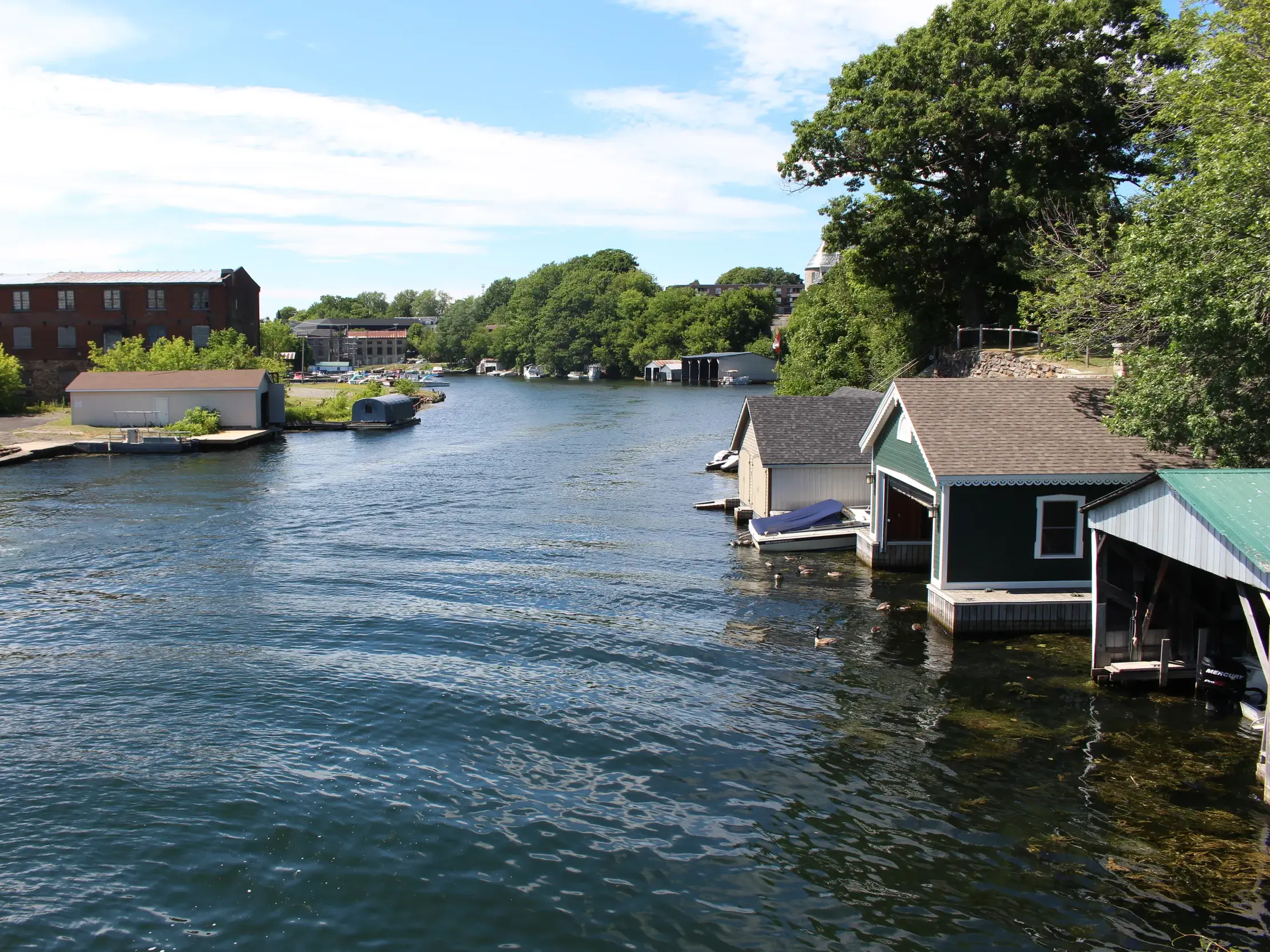 Malerische Bootshäuser am Ufer des Sankt-Lorenz-Stroms in der Region Thousand Islands während einer Radreise in Ostkanada.