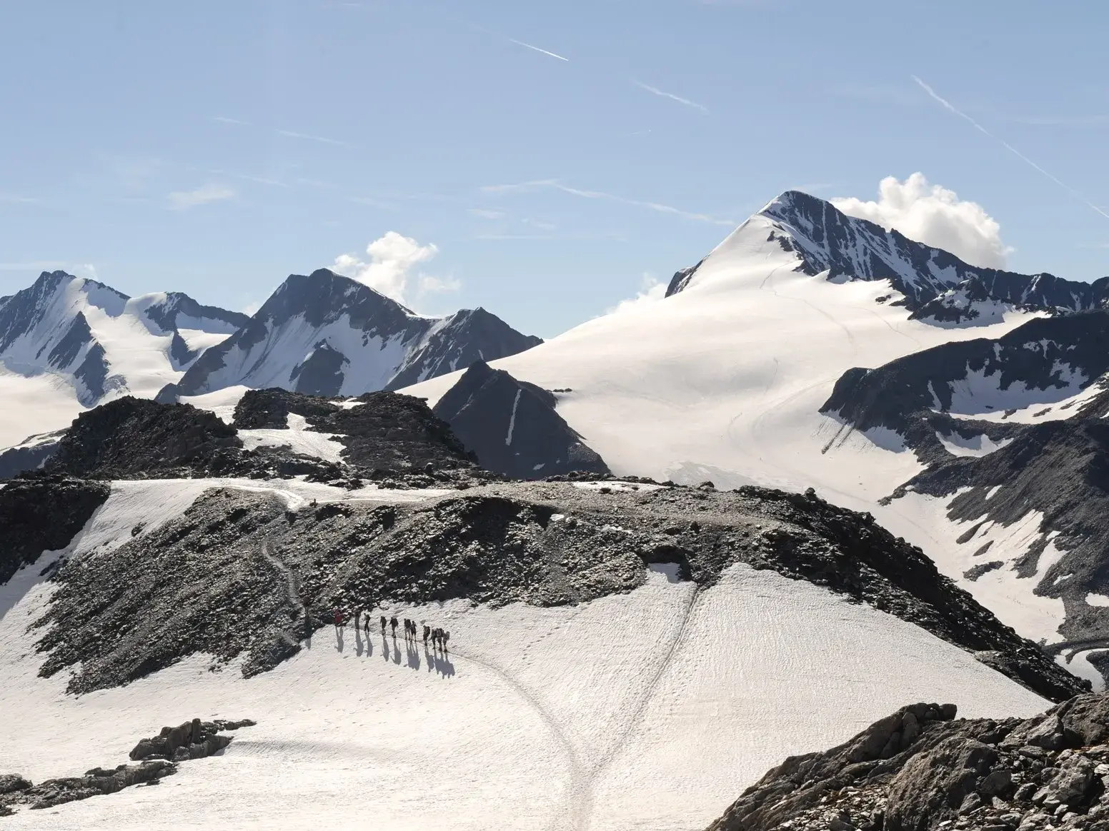 Eine Wandergruppe auf dem Panoramahöhenweg in den Ötztaler Alpen mit Blick auf die majestätische Gletscherwelt der Wildspitze.