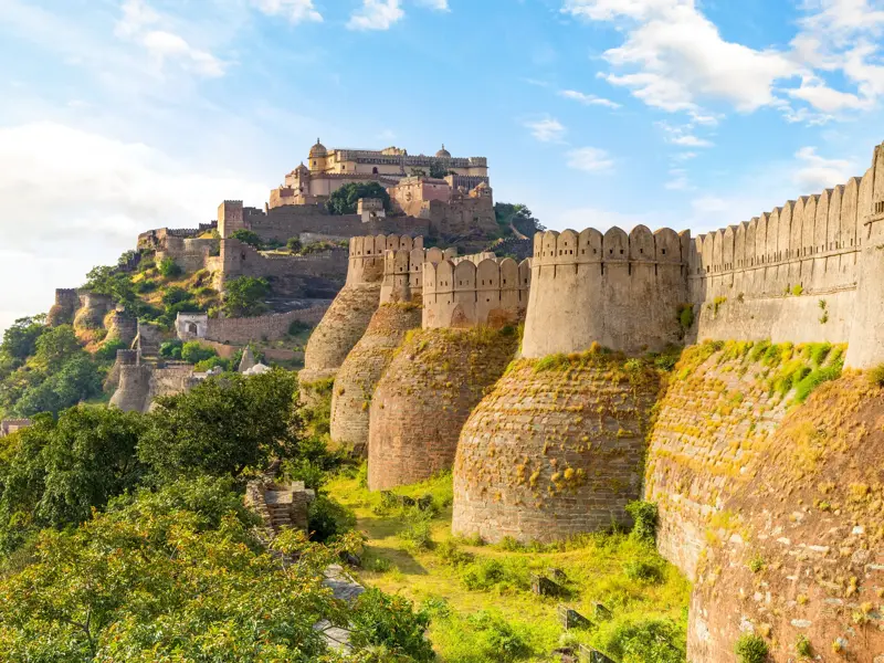 Die mächtige Festungsmauer des Kumbhalgarh Forts mit ihren runden Bastionen in der grünen Hügellandschaft Rajasthans.
