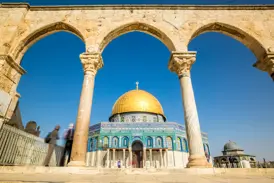 Studienreise in Jerusalem: Der prächtige Felsendom mit Goldkuppel, gesehen durch historische Arkaden auf dem Tempelberg.