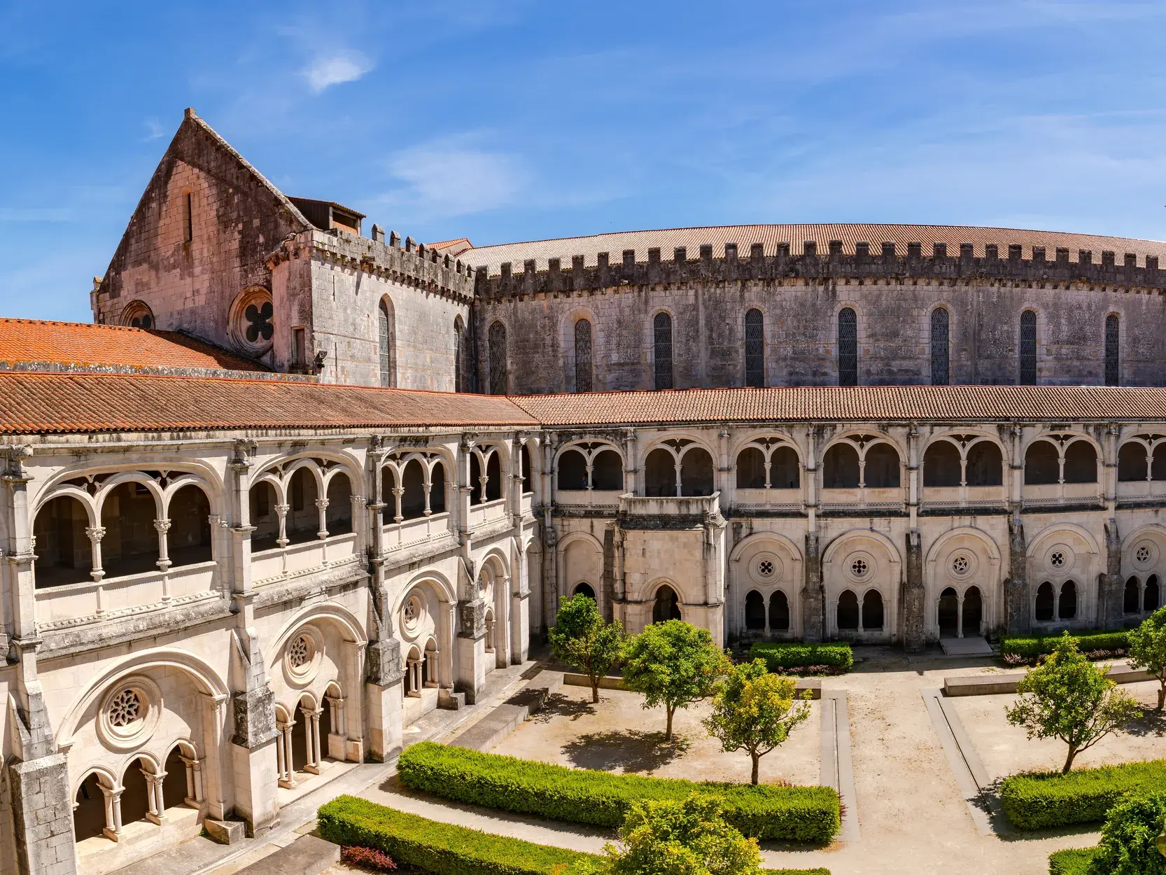 Gotischer Kreuzgang mit Innenhof der Zisterzienserabtei Alcobaca, ein UNESCO-Welterbe in Portugal, bei Sonnenschein.