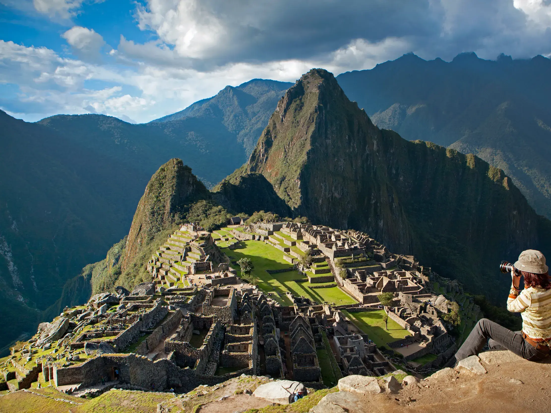Eine Teilnehmerin einer Kleingruppenreise fotografiert die beeindruckende Inkastadt Machu Picchu in den Anden Perus.