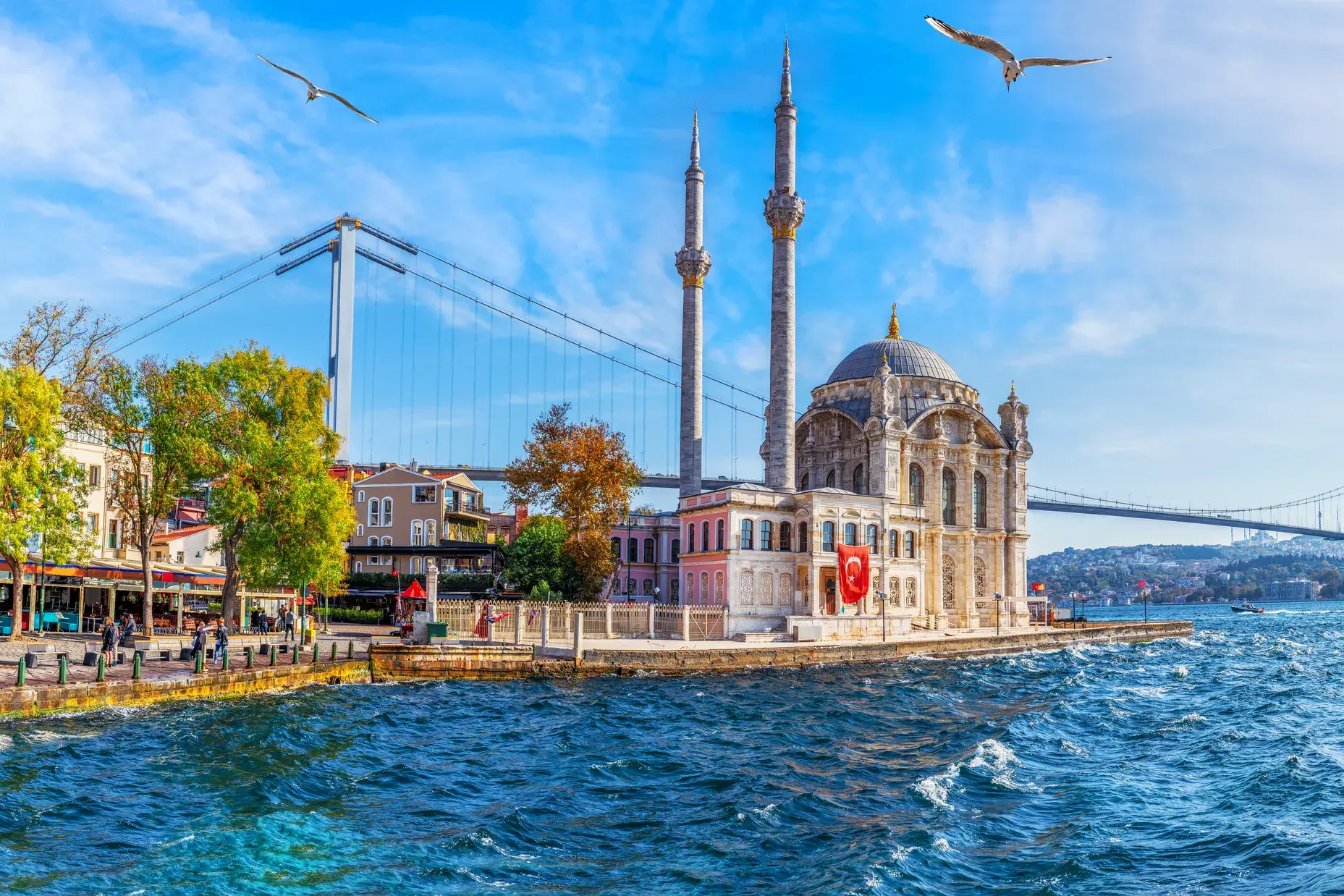 Blick vom Bosporus auf die prachtvolle Ortaköy-Moschee und die große Brücke bei einer Fährfahrt durch Istanbul.