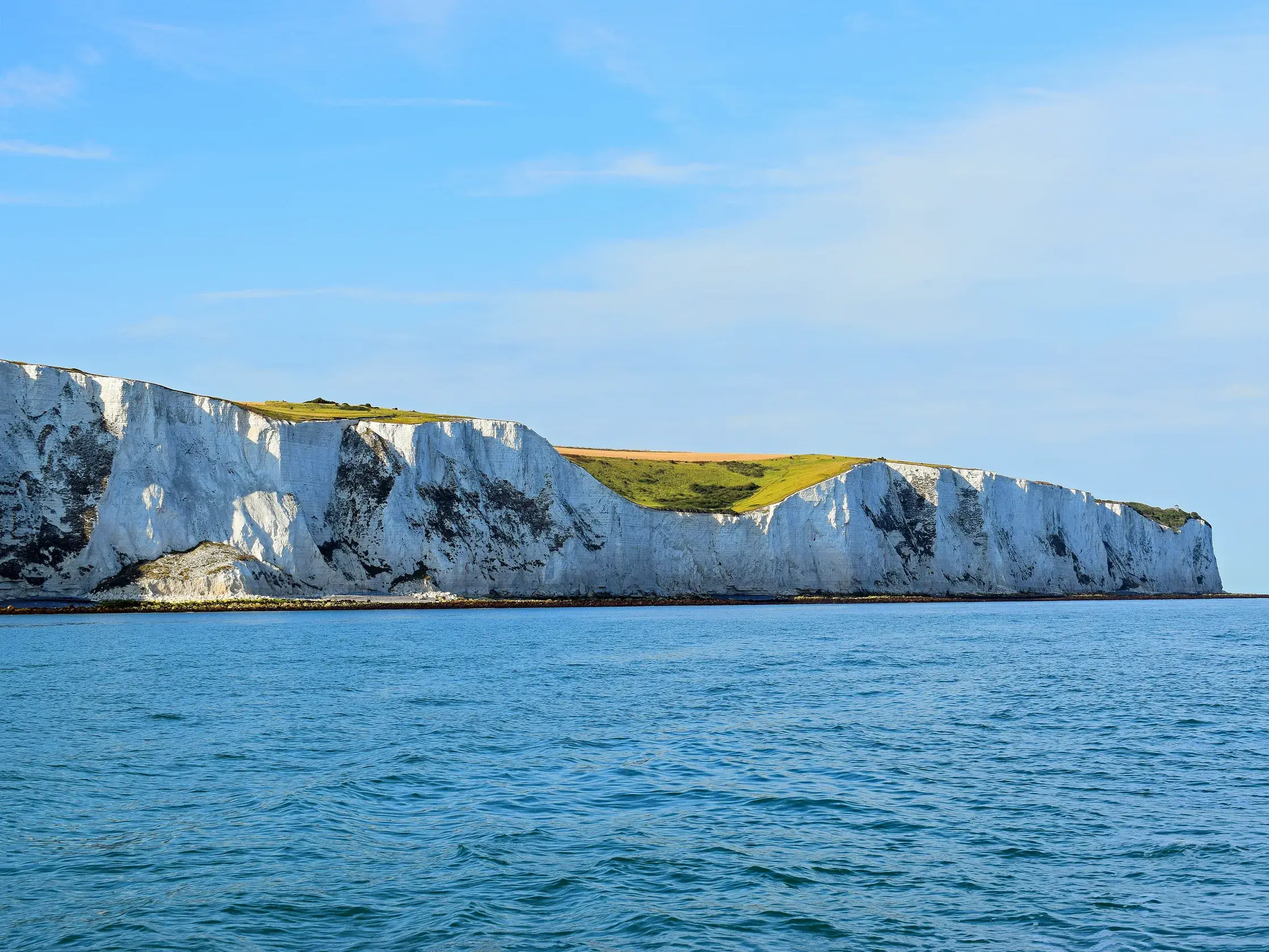Die majestätischen weißen Kreideklippen von Dover ragen über dem blauen Meer empor, ein Höhepunkt der Studienreise in Südengland.