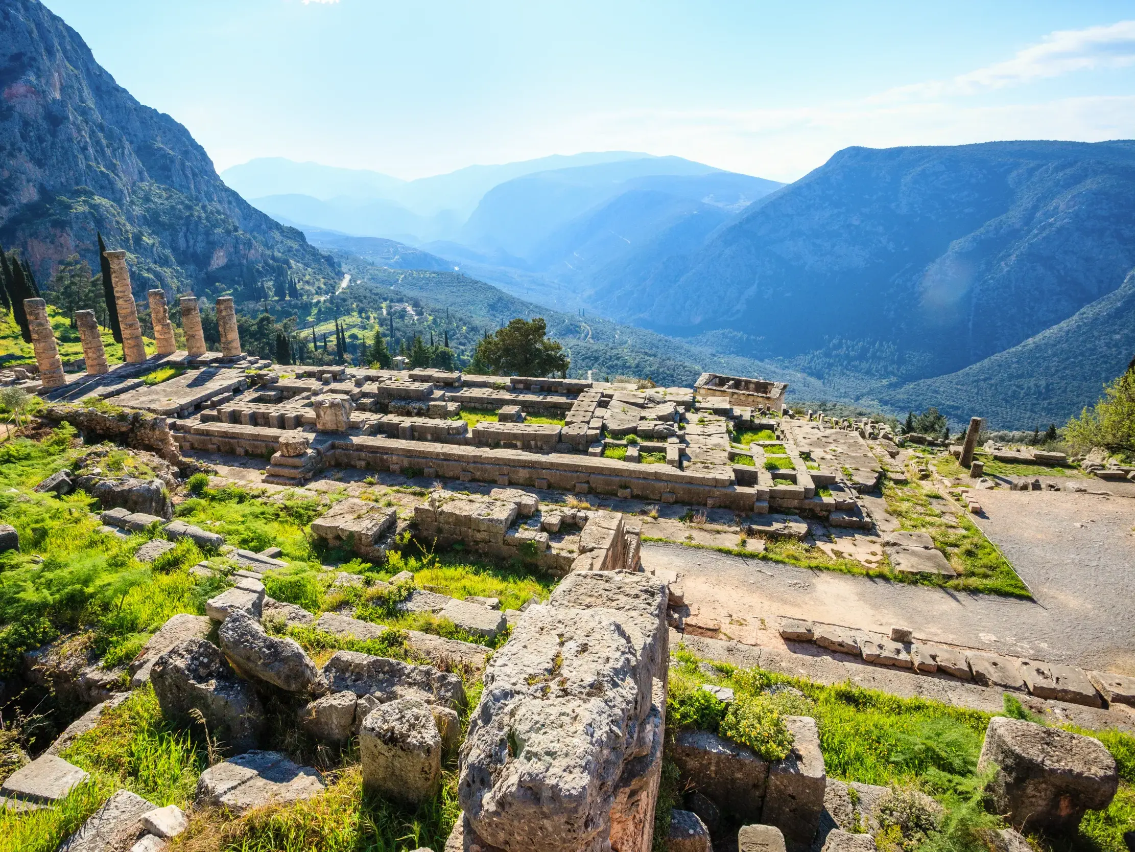 Sonniger Panoramablick über die antiken Ruinen des Apollotempels in Delphi und das weite Tal des Parnassgebirges.