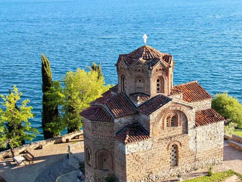 Die historische Kirche Sveti Jovan Kaneo aus Stein an der Steilküste über dem tiefblauen Ohrid-See in Nordmazedonien.