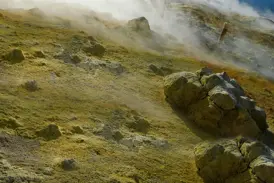 Gelbe Schwefelablagerungen und aufsteigende Fumarolen an einem nebligen Hang des Vulkans auf der Äolischen Insel Vulcano.