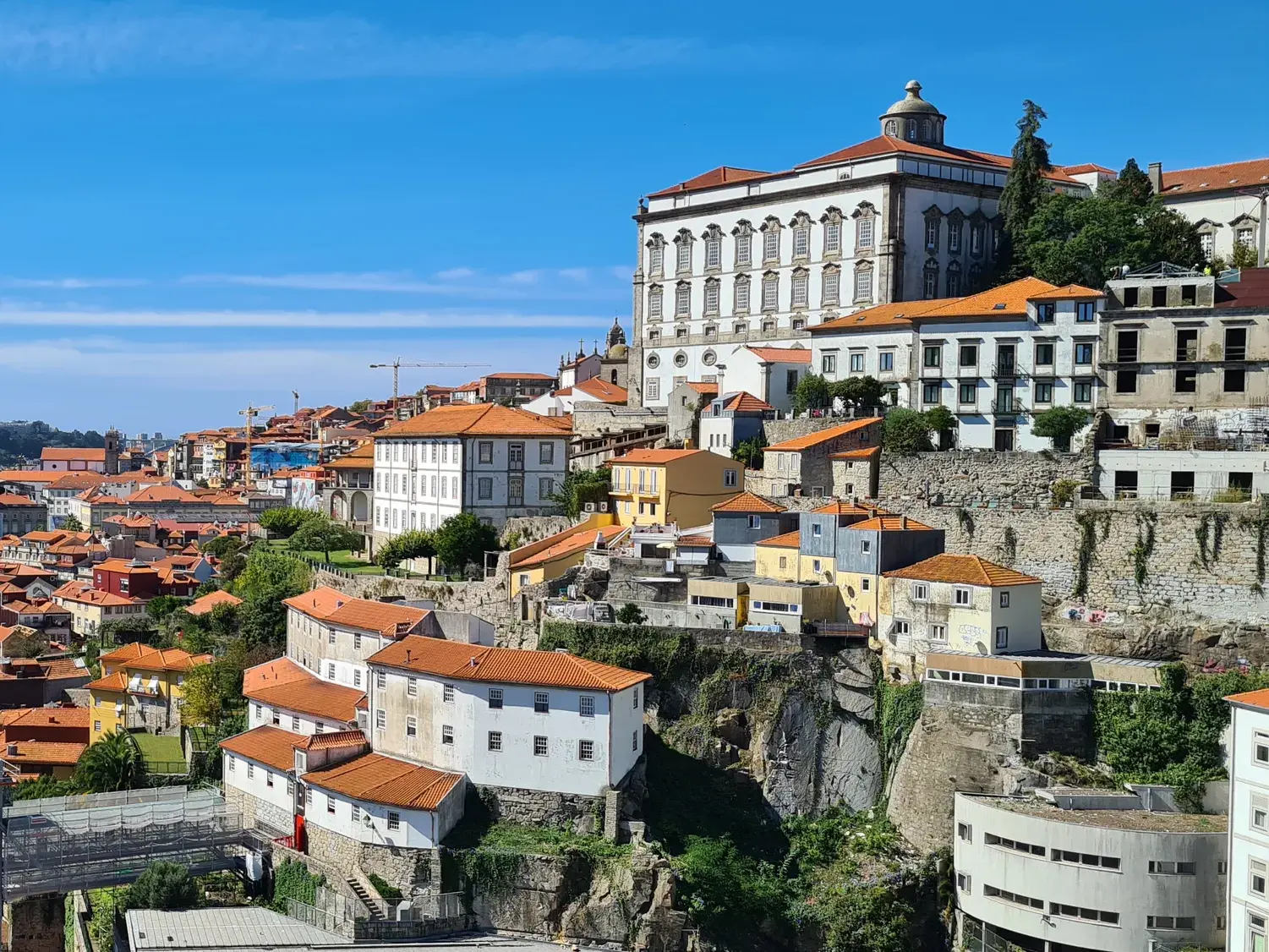 Historische Altstadt von Porto mit bunten Häusern, die sich am Hang unterhalb des Bischofspalastes aneinanderreihen.