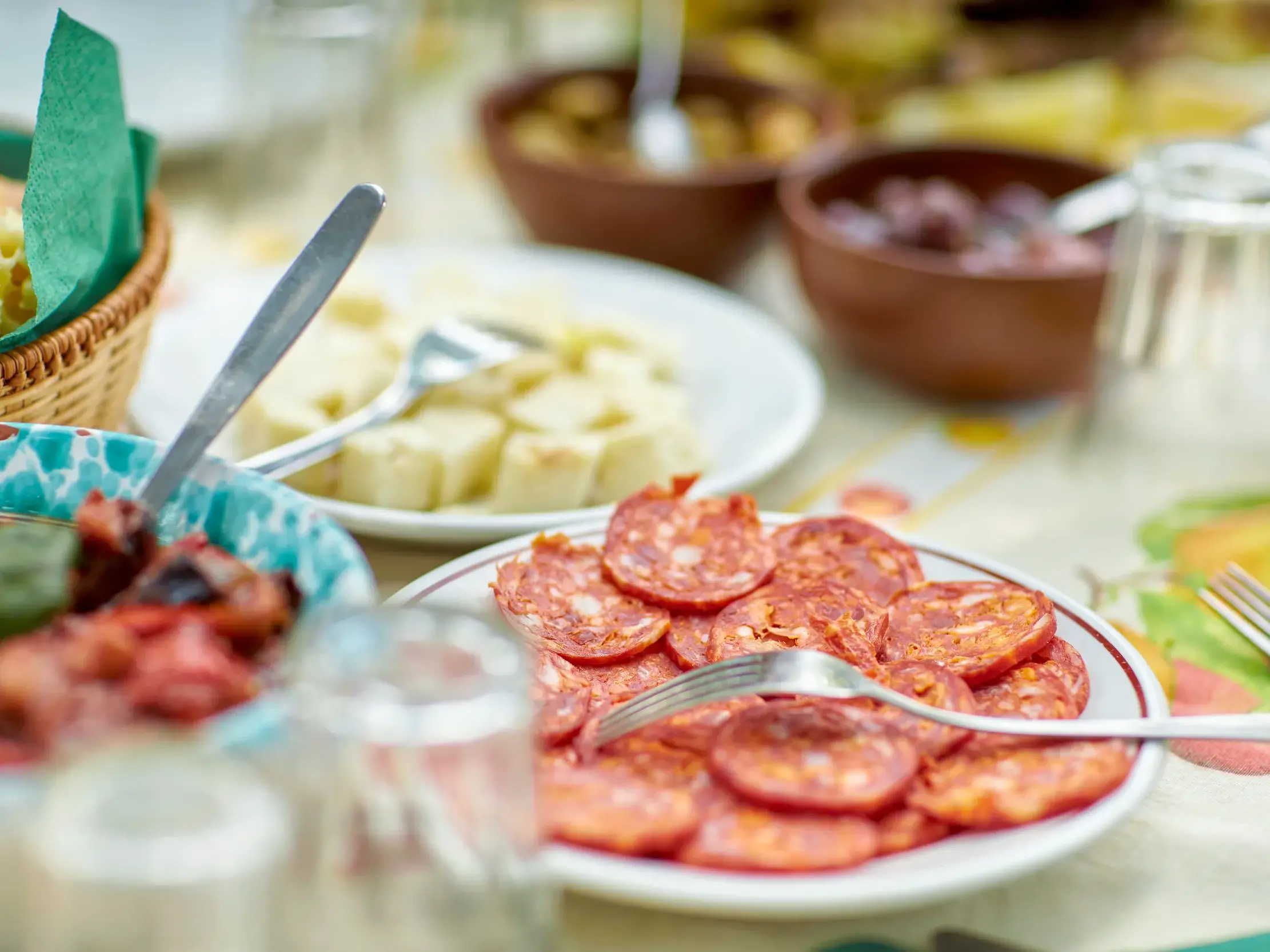 Auf einer Studiosus Studienreise in Sizilien: Tisch mit landestypischen Antipasti wie Salami, Käsewürfeln und Oliven.