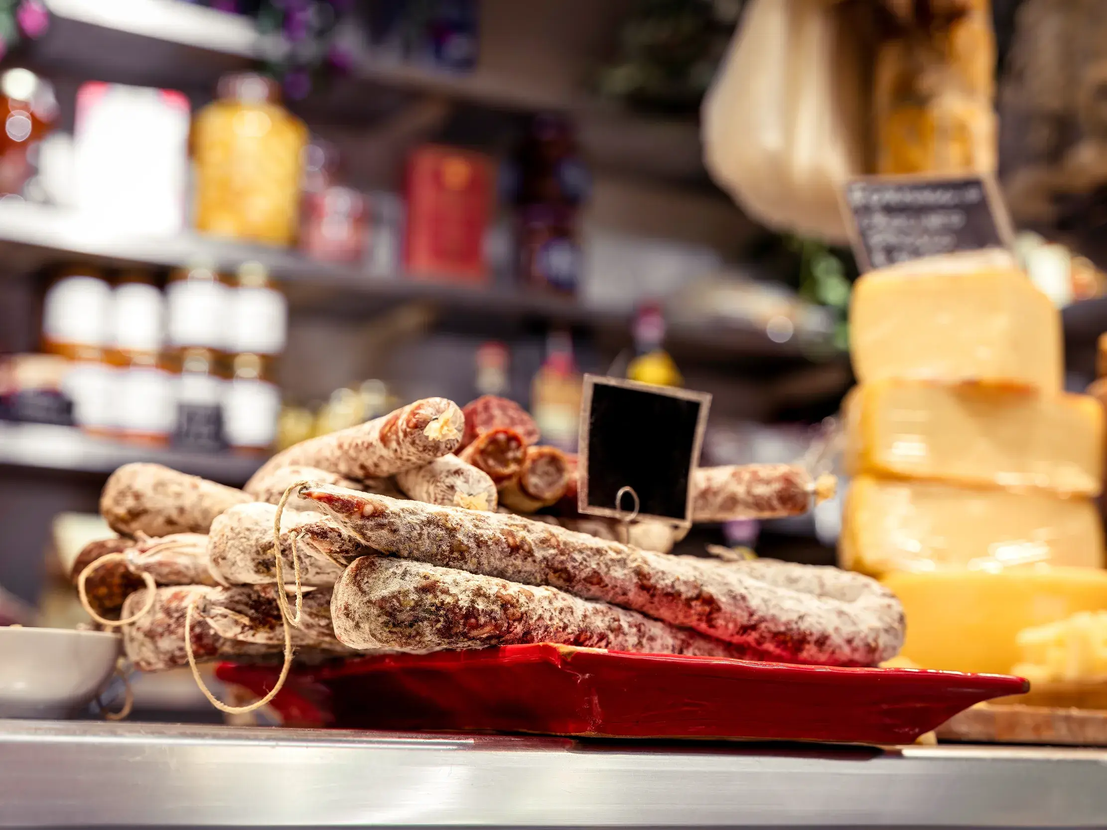 Auslage mit traditioneller italienischer Salami und Käse auf einem Marktstand im Mercato Centrale in Florenz.