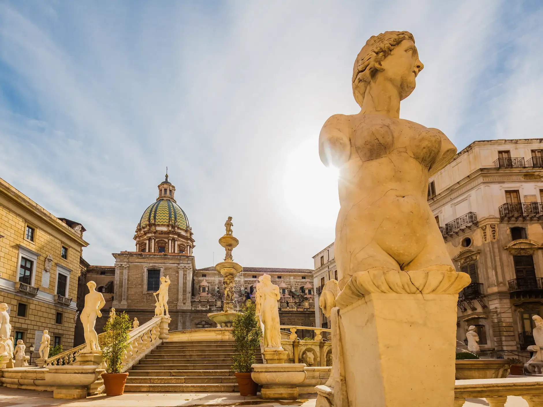 Marmorstatuen der Fontana Pretoria vor historischer Kirchenkuppel in Palermo auf Sizilien
