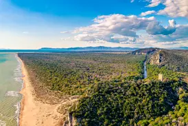 Weitläufiger Blick über den Parco Naturale della Maremma in der Toskana: Sandstrand, Meer, Pinienwälder und ein Wachturm.
