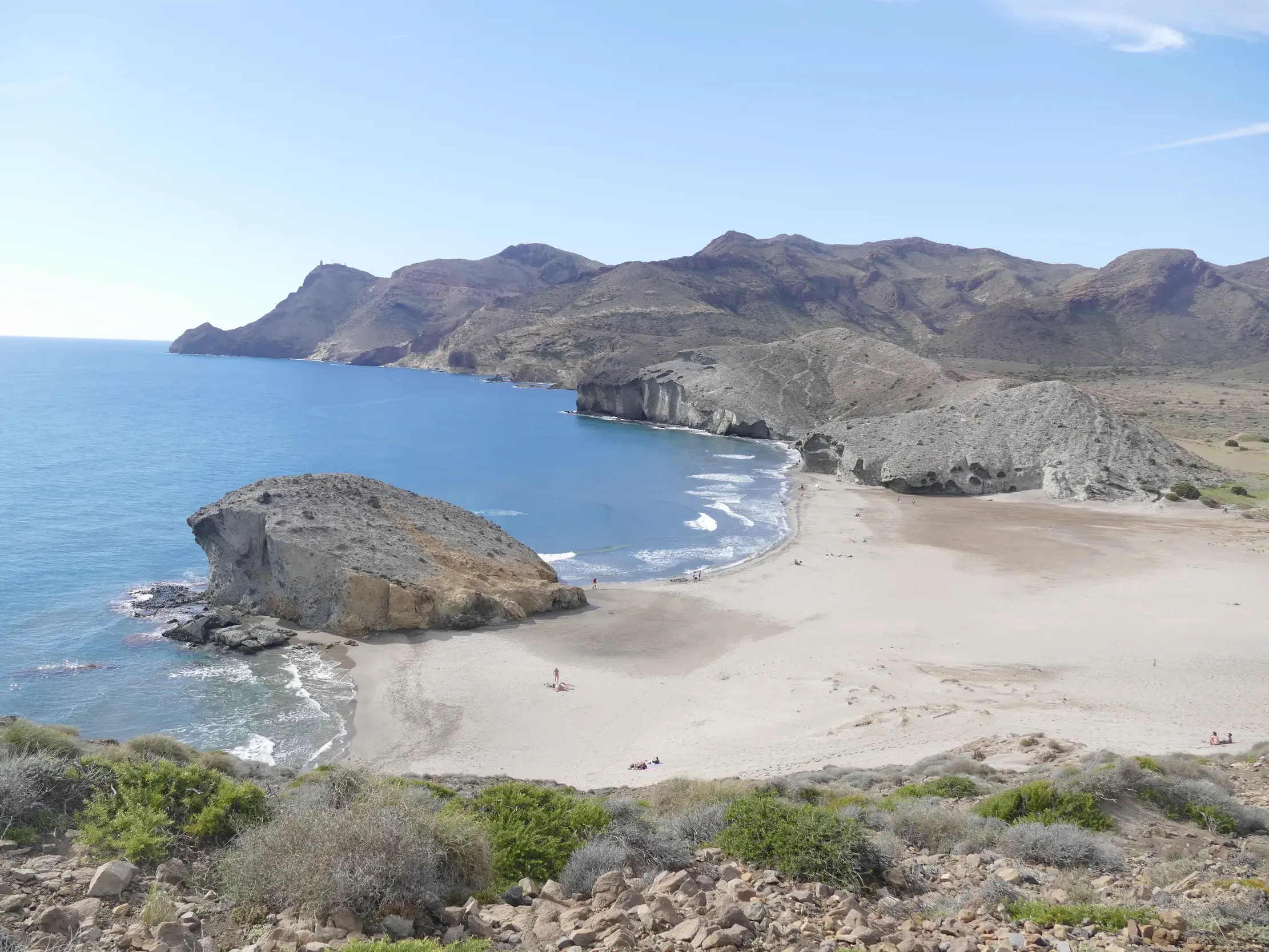 Panoramablick bei einer Wanderung auf eine einsame Sandbucht mit Felsen und blauem Meer im Naturpark Cabo de Gata.
