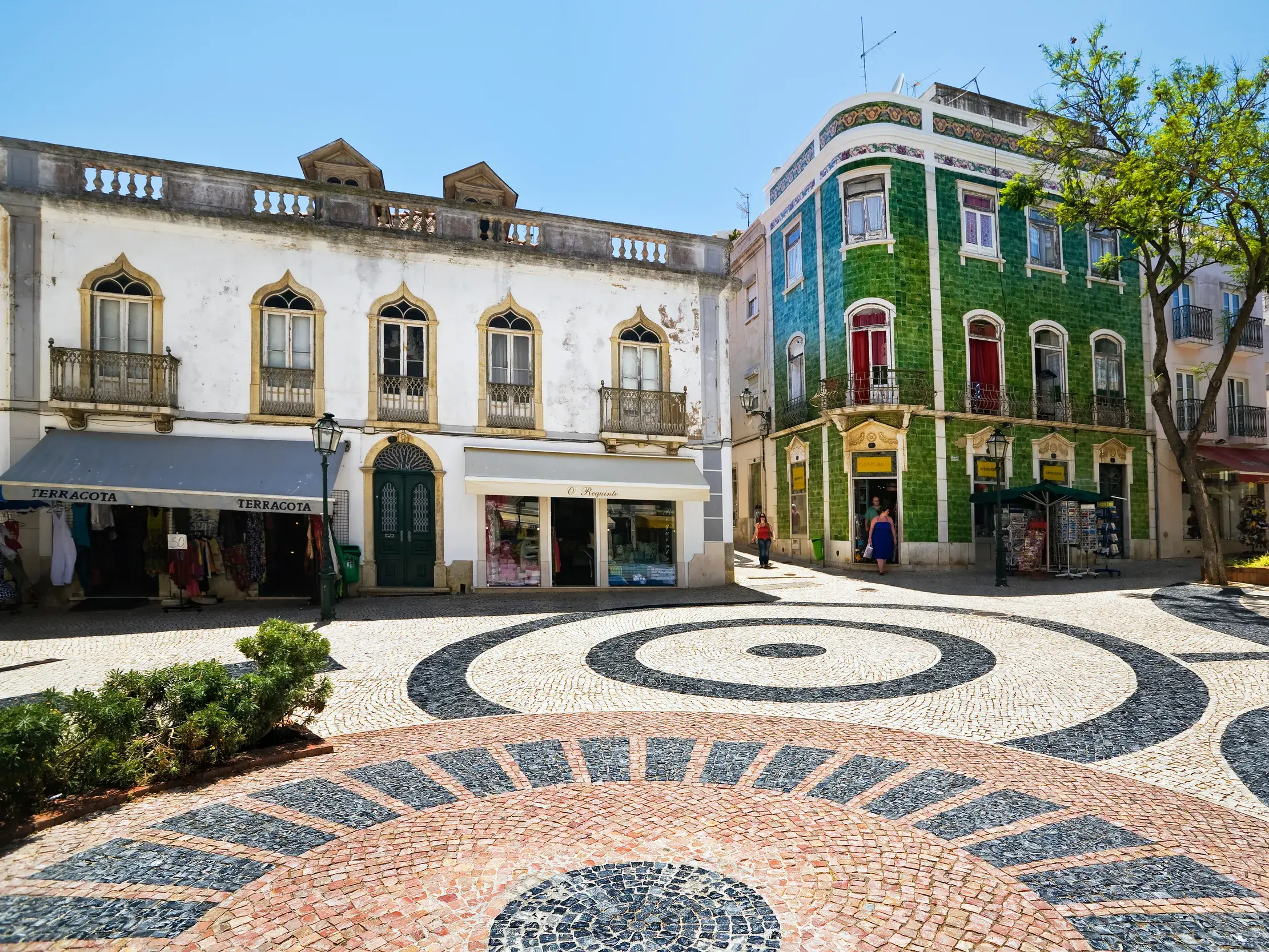 Sonniger Stadtplatz in Lagos mit kunstvollem Mosaikpflaster und historischen Häusern mit bunter Kachelfassade.